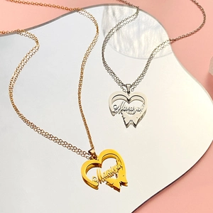 Macro detail of custom heart butterfly name necklace in polished gold and silver finishes