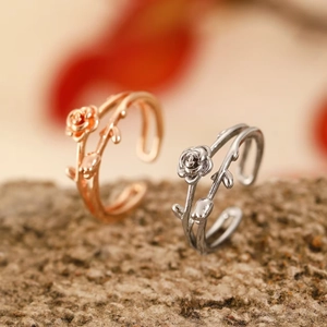Detailed close-up of rose flower vine rings in rose gold and silver finishes