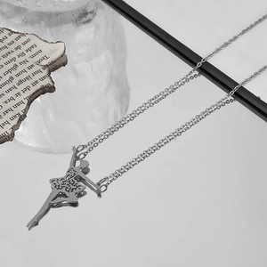 Detailed close-up of a silver stainless steel ballerina pendant with intricate cutout patterns