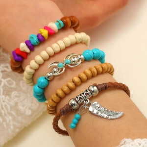 Dettaglio di bracciali bohémien con turchese, perle di legno e ciondoli etnici