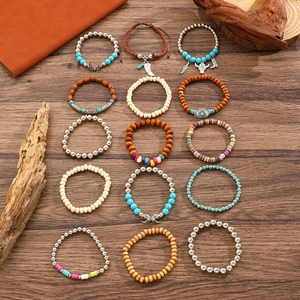 Set aus 15 Boho-Armbändern mit Türkis, Holzperlen und ethnischen Anhängern auf Holz
