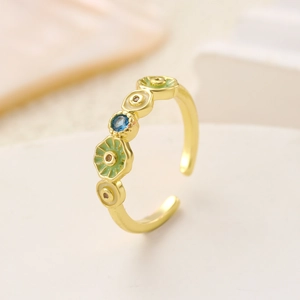 Adjustable gold flower ring with green enamel, white dots, and a central blue gemstone