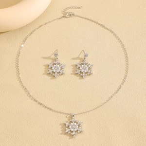 Detailed macro view of silver snowflake jewelry set with white pearls and sparkling crystals