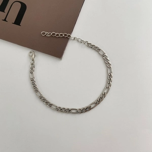 Macro detail of Figaro chain link bracelet with lobster clasp and adjustable extension
