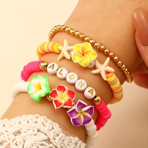 Primer plano detallado de pulseras bohemias con cuentas de arcilla y dijes de mar