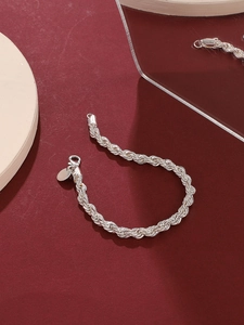 Silver twist rope chain bracelet with lobster clasp on elegant red background