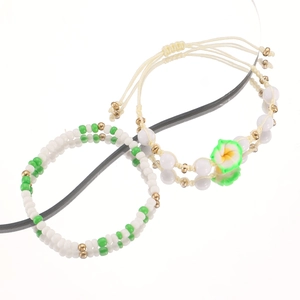 Vista detallada de la pulsera de cuentas hecha a mano con dije de flor y nudo ajustable
