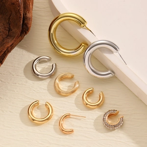 Détails de diverses créoles dorées et argentées et de boucles d'oreilles à strass