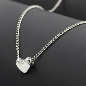 Elegante collar de corazón plateado con acabado pulido espejo en una cadena delgada