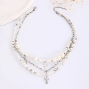 Detail der mehrlagigen Perlen-Choker-Halskette mit Strass-Kreuz und Stern-Anhängern