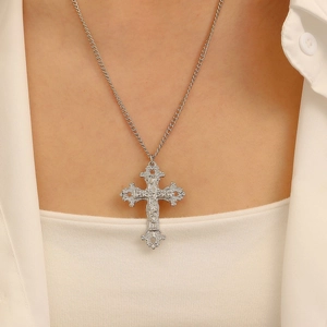 Close-up of vintage baroque cross necklace with intricate relief and silver finish