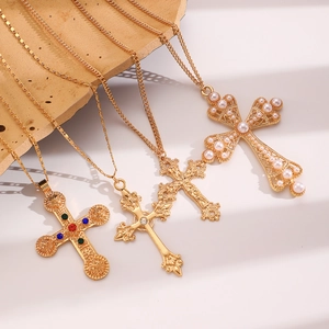 Macro view of gold-plated cross pendants with colorful crystals and pearl details