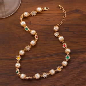 Macro shot of colorful gemstone pendant and white pearls on vintage gold plated necklace