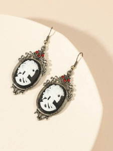Makroaufnahme gotischer Vintage-Silberohrringe mit Totenkopfrelief und roten Steinen