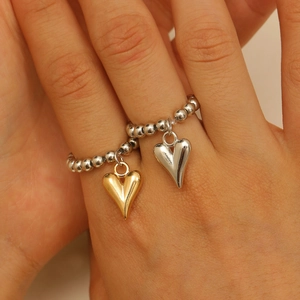 Détail de la bague en perles avec pendentifs coeurs polis or et argent sur mannequin