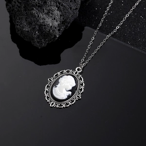 Vintage-Cameo-Halskette mit weißer Silhouette auf Schwarz und silbernem Reliefrahmen