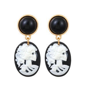 Gotische Vintage-Ohrringe mit schwarzen Edelsteinen und weißem Totenkopf-Porträt in Gold