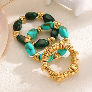 Détail de trois bracelets élastiques à perles avec des pendentifs dorés