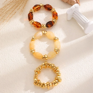 Detailed view of 3-piece beaded bracelet set with amber resin and gold metal accents