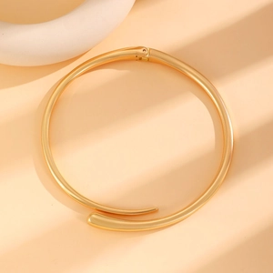 Detailed view of polished gold water drop collar necklace with a modern hinge closure