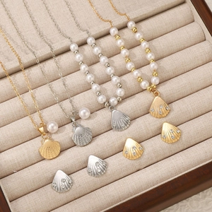 Detail view of shell pendants with diamonds and pearls in gold and silver jewelry sets