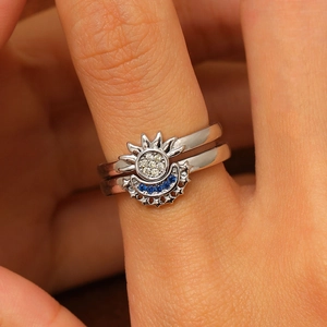 Close-up of silver sun and moon stacking ring set with blue and white zircons
