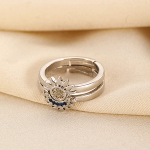 Macro shot of sun and moon couple rings with blue and yellow stones on satin