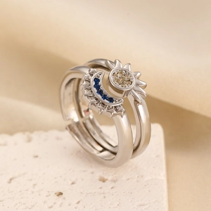 Macro shot of sun and moon couple rings with blue and yellow zircons on textured stone