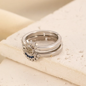 Close-up of sun and moon stacking rings with sparkling stones on textured stone background