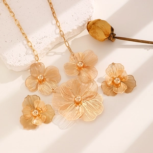 Macro detail of gold flower necklace and earrings with delicate wire mesh petals