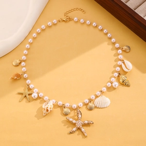 Détail du collier de perles bohème avec breloques étoile de mer dorée et coquillage marin