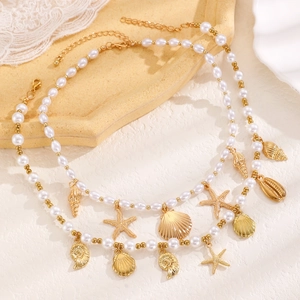 Detail of seashell, starfish and conch charms on a layered pearl necklace set