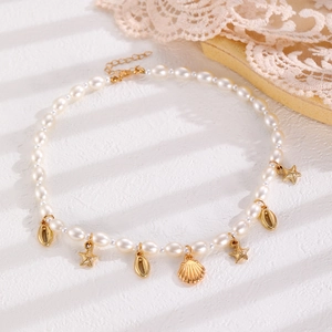 Detail view of summer beach necklace with gold seashell, starfish charms and pearls