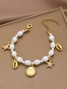 Detailed view of pearl beaded bracelet with golden starfish, seashell, and conch charms