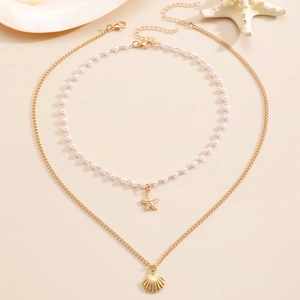 Detail of layered beach necklace with pink beads, gold starfish and seashell pendants