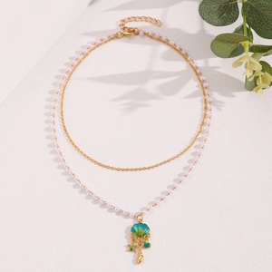 Detail of layered gold chain with pearl beads and colorful shell starfish pendants