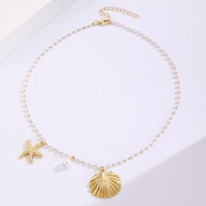 Close-up of ocean-themed necklace with gold starfish, pearl, and shell charms on beads
