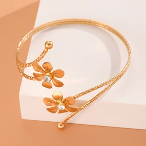 Bracelet de bras doré avec fleurs en cristal et fini métal martelé sur un support