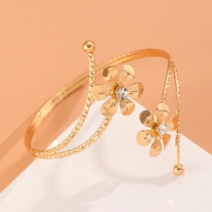 Détail du bracelet de bras floral doré avec strass brillants et anneau en spirale