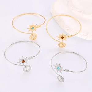 Détail de bracelets de bras en forme de soleil avec pierres colorées en or et argent