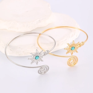 Détail de bracelets manchettes soleil en or et argent avec pierres turquoise centrées