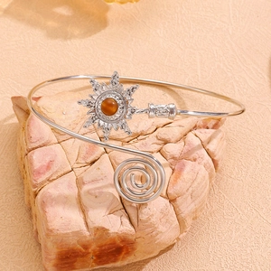 Détail d'un bracelet manchette fleur soleil en argent avec œil de tigre sur pierre