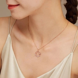 Rose gold necklace with floral wreath pendant and diamonds worn by a model