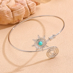 Détail d'un bracelet de bras bohème argenté avec pendentif soleil et pierre bleue