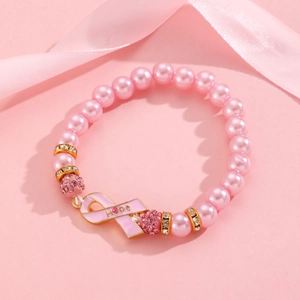 Détail macro d'un bracelet de perles roses avec un pendentif ruban rose symbole d'espoir