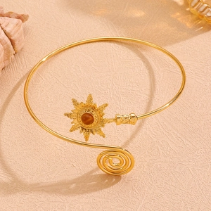 Détails macro d'un bracelet de bras bohème doré avec motif soleil et pierre centrale sertie
