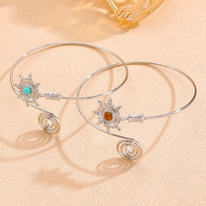 Détail de bracelets de bras bohèmes argentés avec des accents floraux en turquoise et ambre