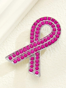 Macro shot of pink ribbon brooch with brilliant deep pink rhinestones on silver alloy