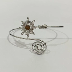 Détail du bracelet de bras fleur argentée avec pierre précieuse brune et motif en spirale