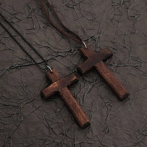 Flat lay of vintage wooden cross pendants with black metal bead chain and brown faux leather cord